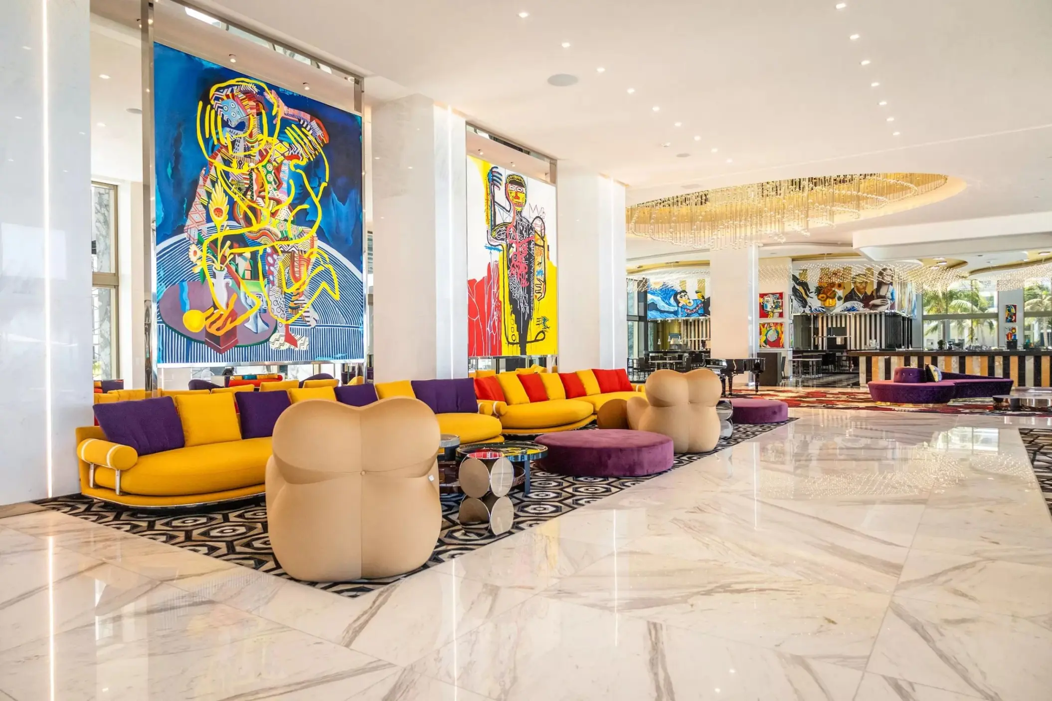 Modern lobby and piano bar with colorful art and bold seating at Hotel Mousai, Cancun