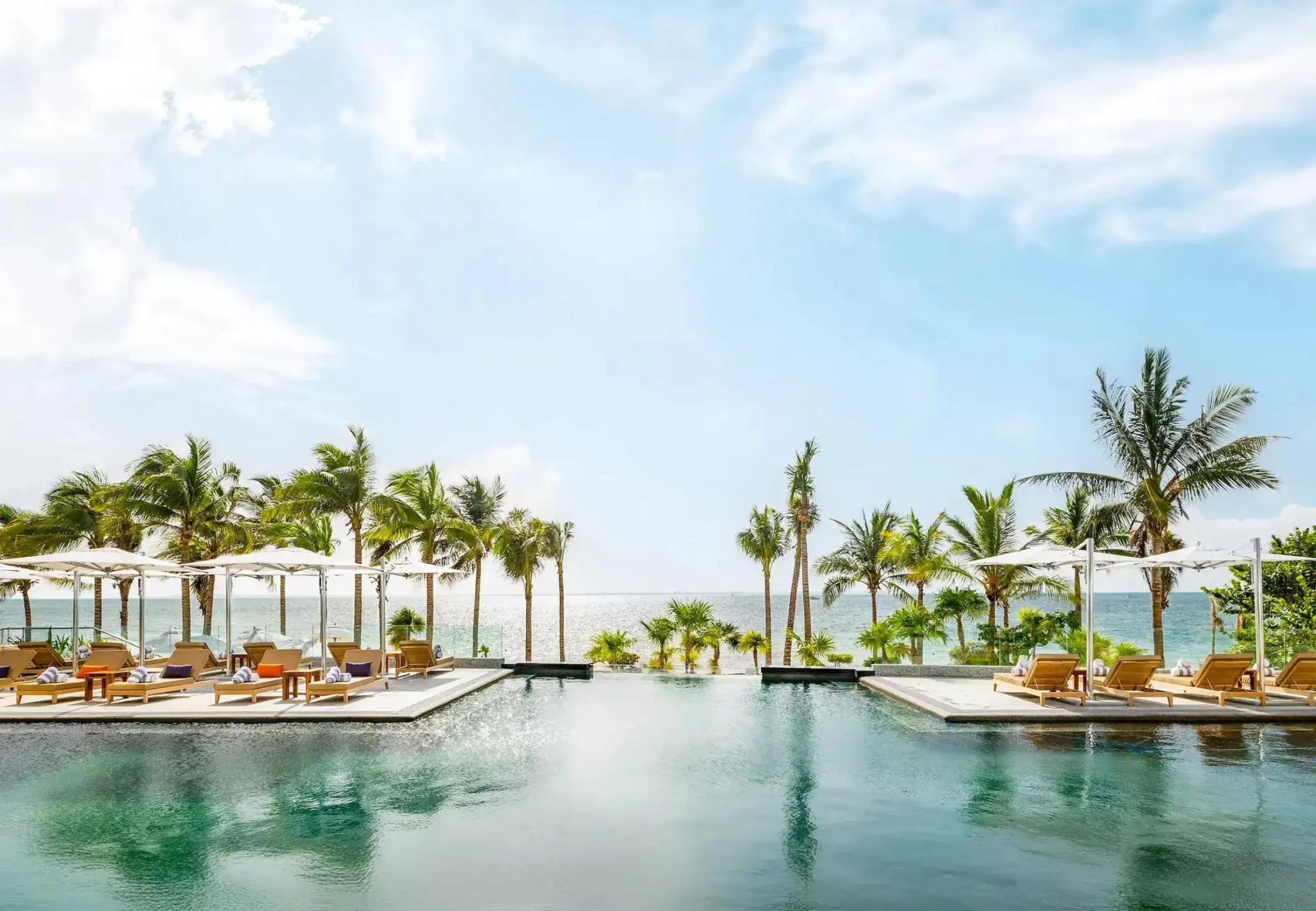 Hotel Mousai Cancun infinity pool with lounge chairs and palm trees, Cancun
