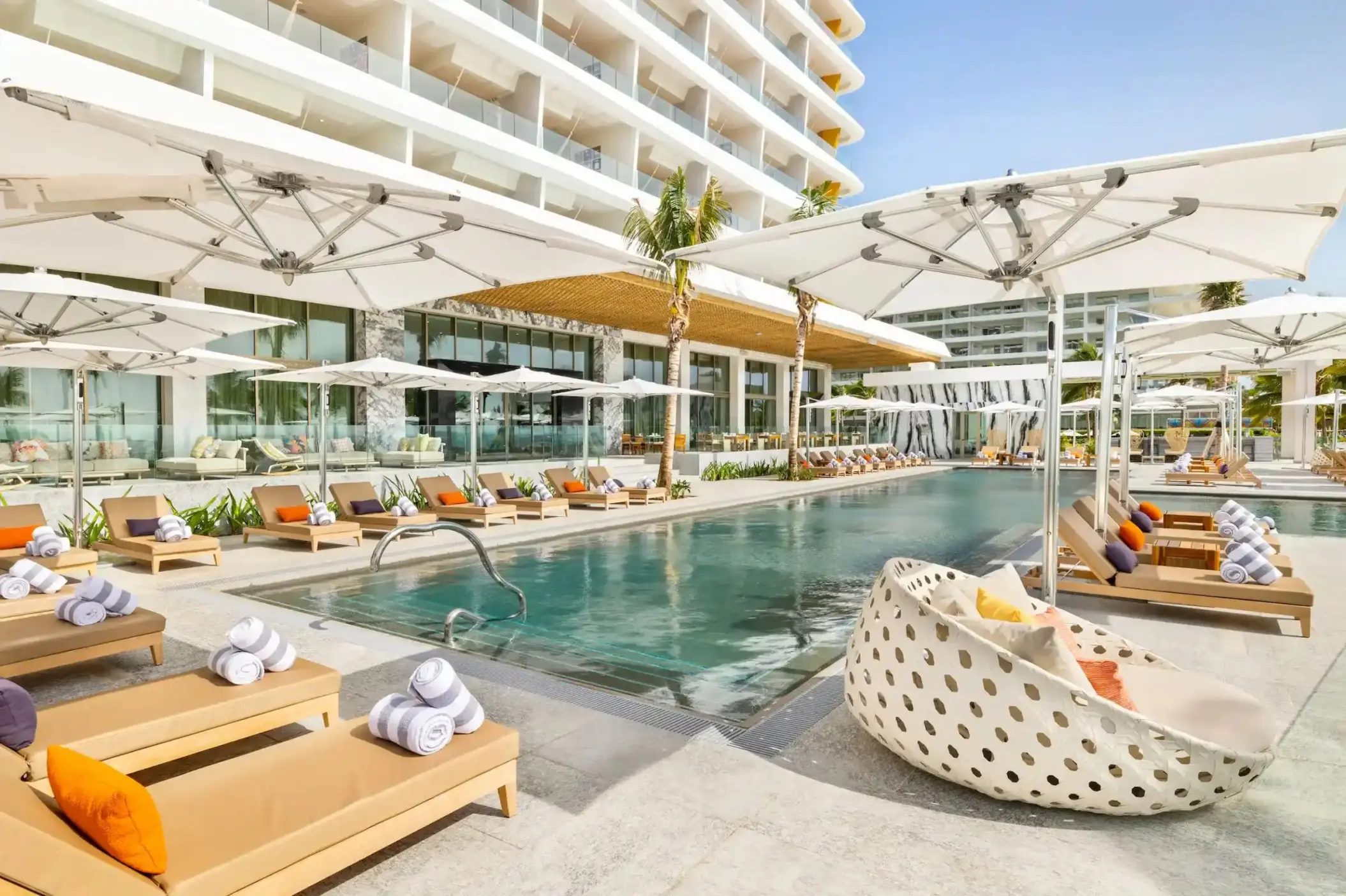Hotel Mousai Cancun outdoor swimming pool with sun loungers and umbrellas, Cancun