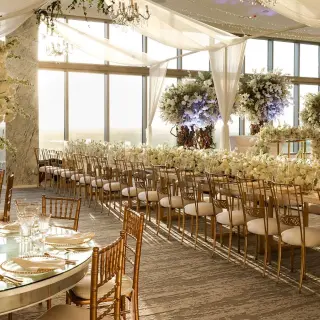 Indoor wedding reception venue with floral arrangements and long tables at Hotel Mousai Cancun