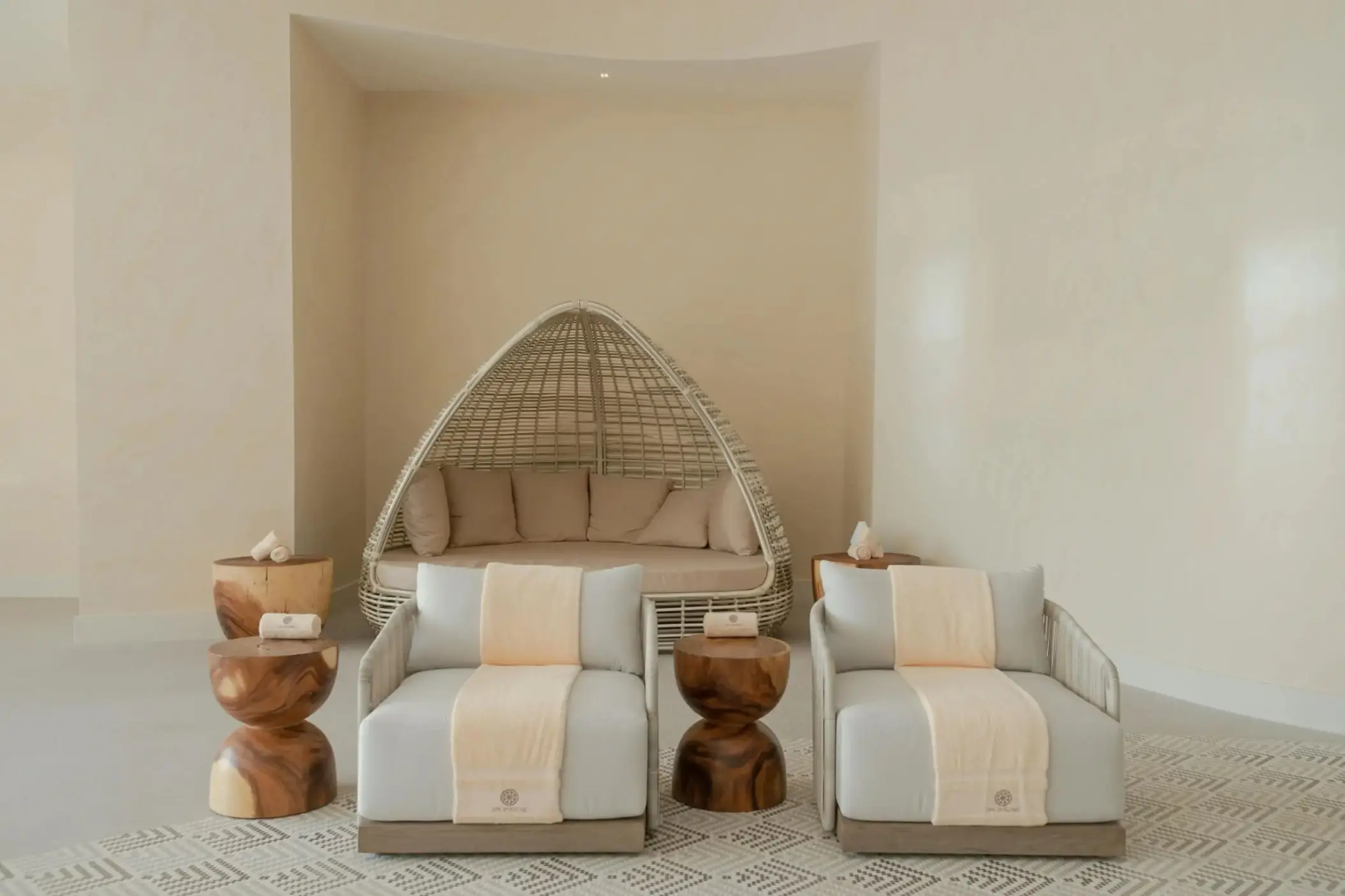 Spa relaxation lounge with woven daybeds and wood side tables at Hotel Mousai, Cancun