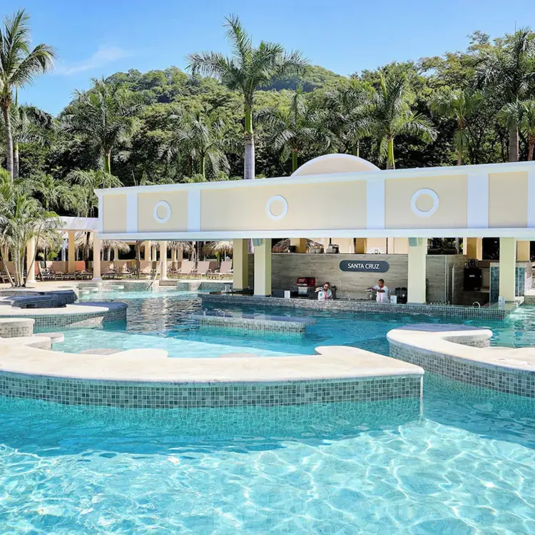 Large outdoor pool with swim-up bar at Riu Guanacaste, Papagayo