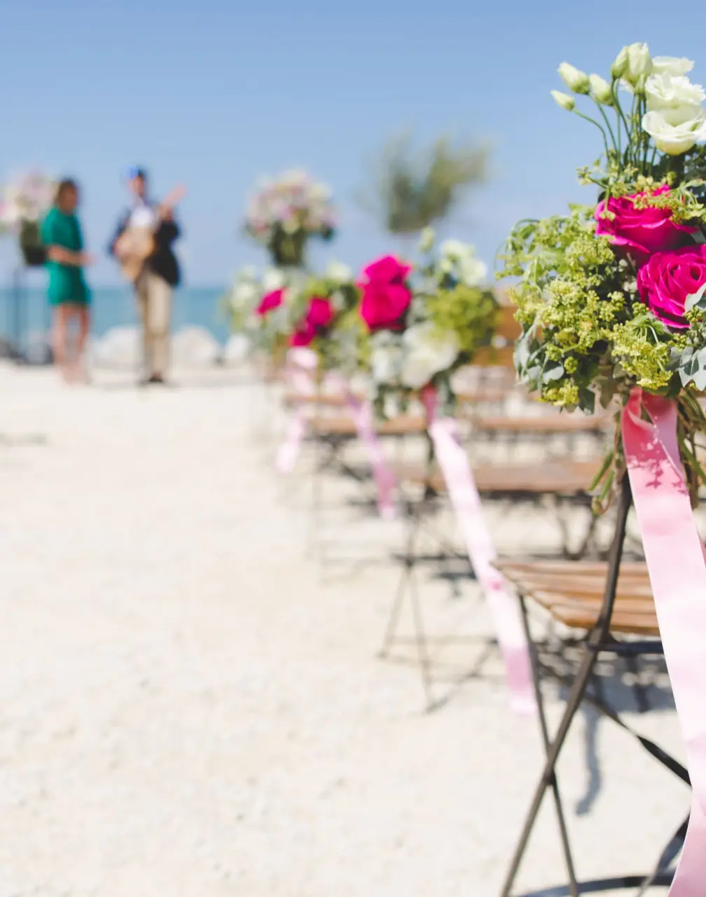Beach wedding ceremony chairs with pink and white flowers at Riu Negril, Negril