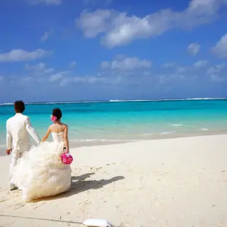 Bride and groom holding hands on the beach