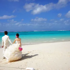 Bride and groom holding hands on the beach
