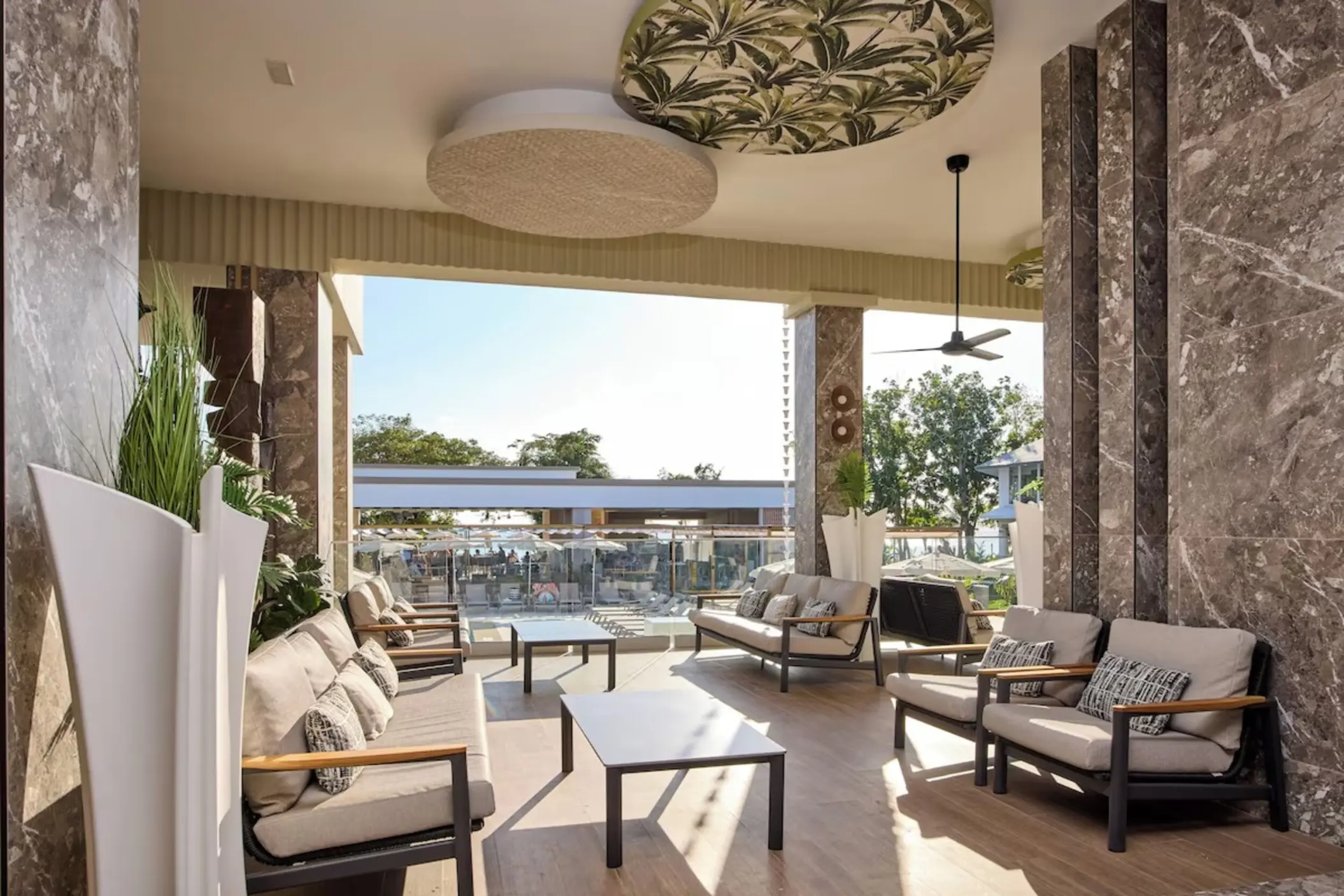 Modern open-air lobby lounge with sofas and marble pillars at Riu Negril, Negril