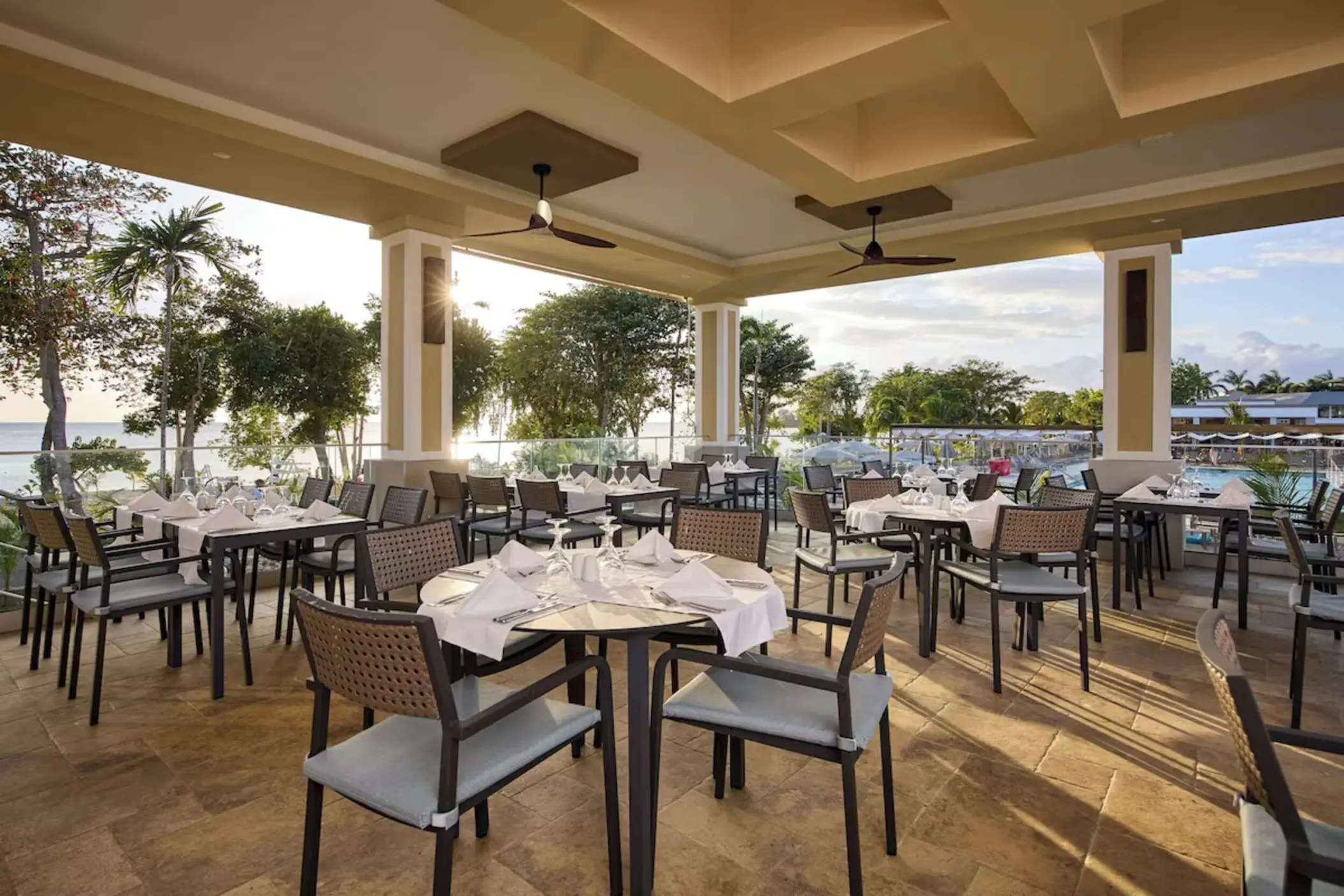 Open-air restaurant dining area with set tables at Riu Negril, Negril