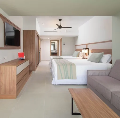 Furnished room with 2 beds and sofa at Hotel Riu Negril