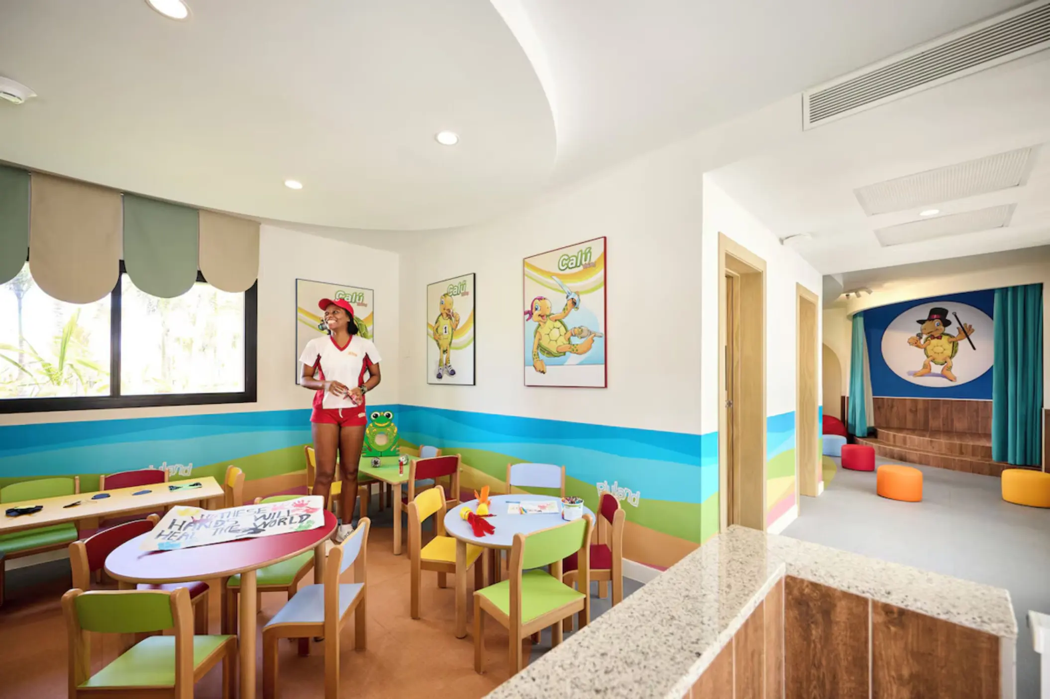 Riu Land kids club indoor play area with small tables and colorful chairs at Riu Palace Aquarelle, Montego Bay