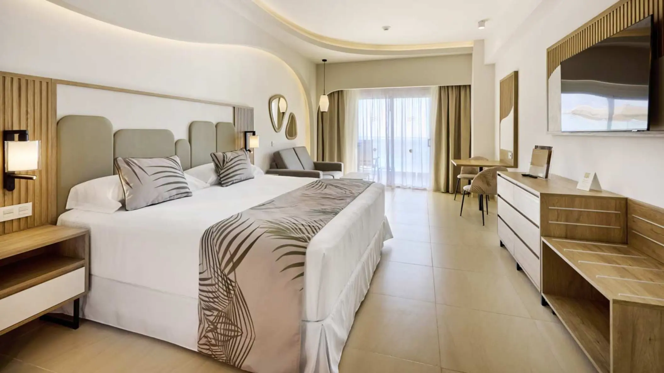 Junior Suite ocean view with white bedding and wood accents at Riu Palace Aquarelle, Montego Bay