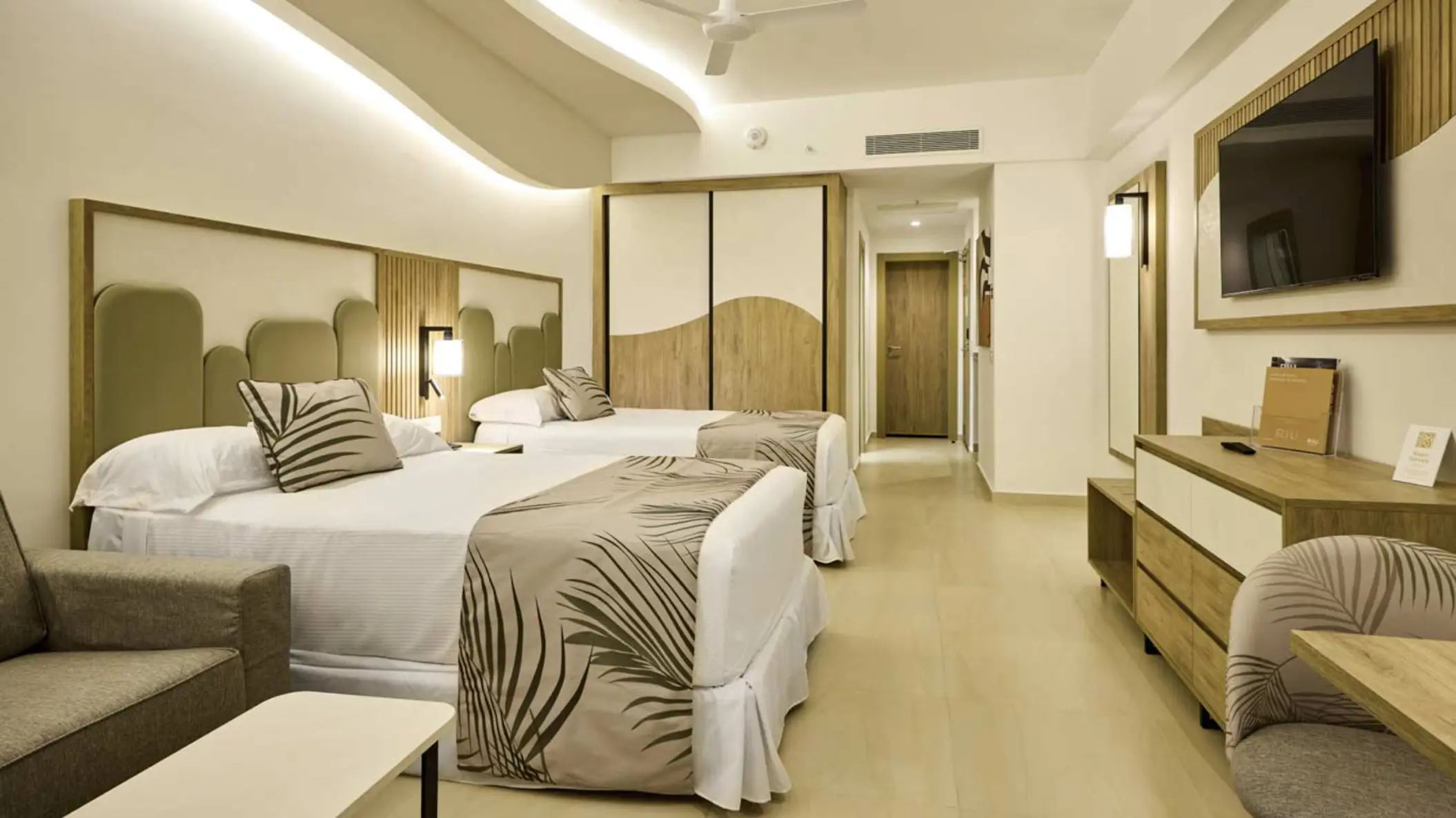 Junior suite with two double beds and modern wood finishes at Riu Palace Aquarelle, Montego Bay