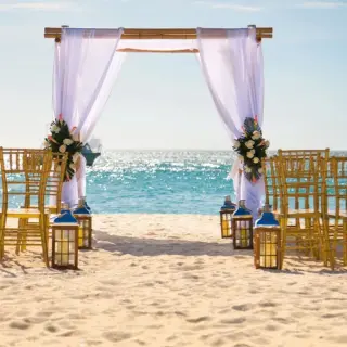 Beachfront wedding ceremony with white draped arch at Riu Palace Aquarelle, Montego Bay