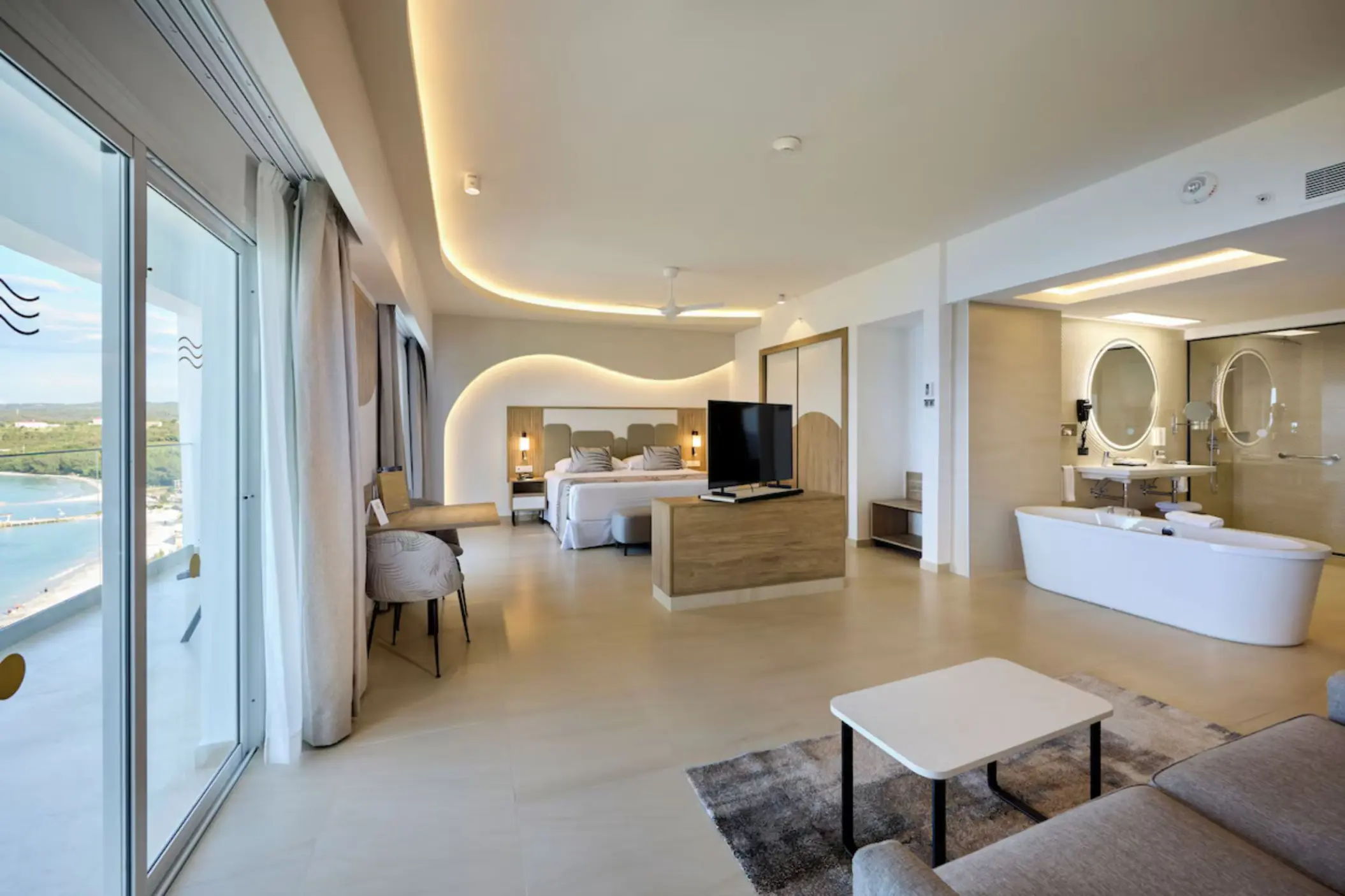 Modern hotel suite with ocean view, bathtub, and living area at Riu Palace Aquarelle, Montego Bay
