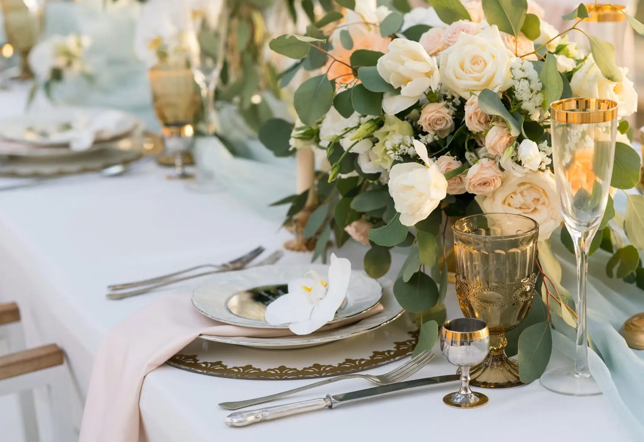 Wedding reception table setup with white roses and eucalyptus at Riu Palace Aquarelle, Montego Bay