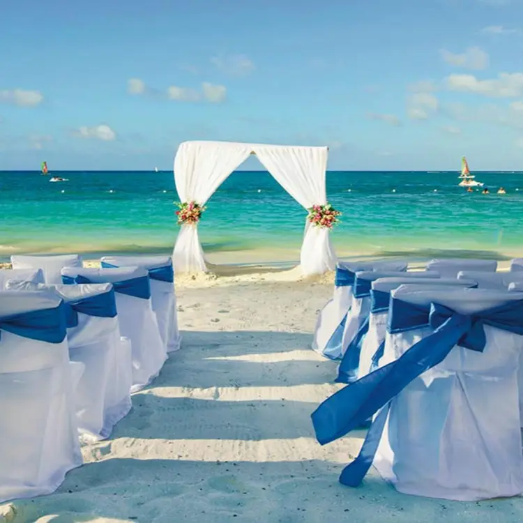 Beachfront wedding ceremony with white arch and blue ribbons at Riu Reggae, Montego Bay