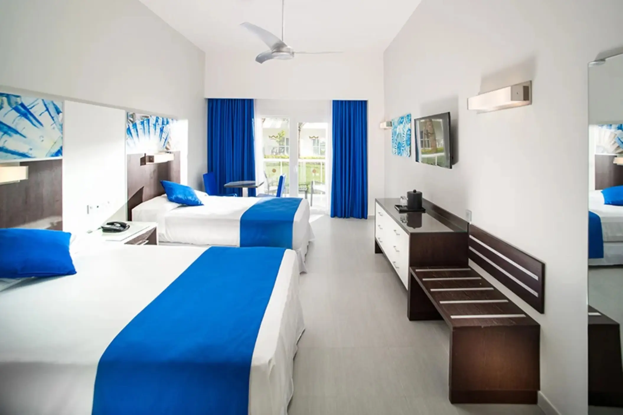 Deluxe room with two double beds and blue accents at Riu Reggae, Montego Bay
