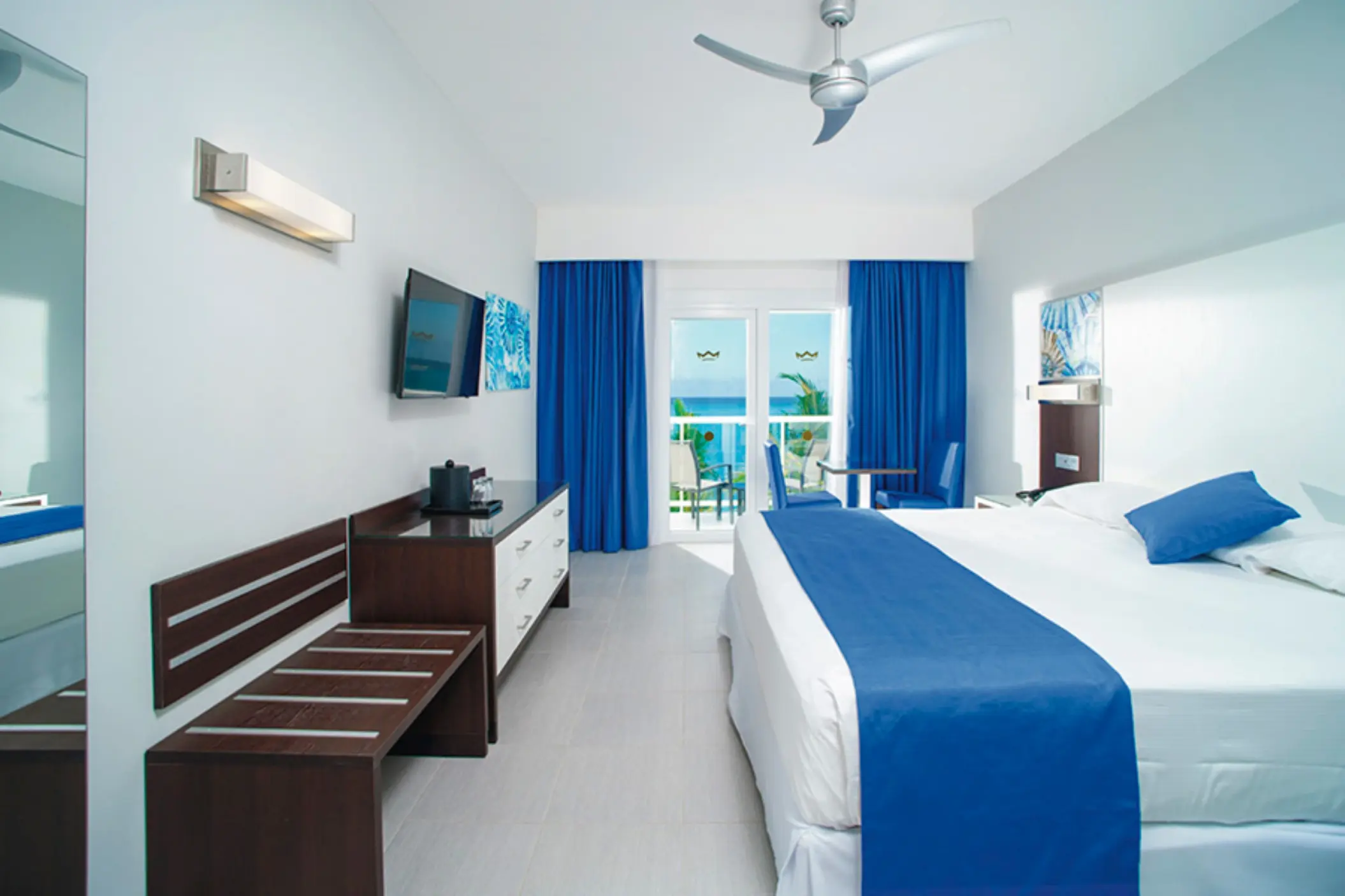 Ocean view suite with blue accents and a private balcony at Riu Reggae, Montego Bay