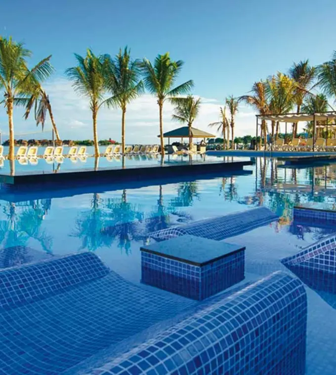 Hotel Riu Reggae infinity pool with submerged tile loungers and palm trees, Montego Bay
