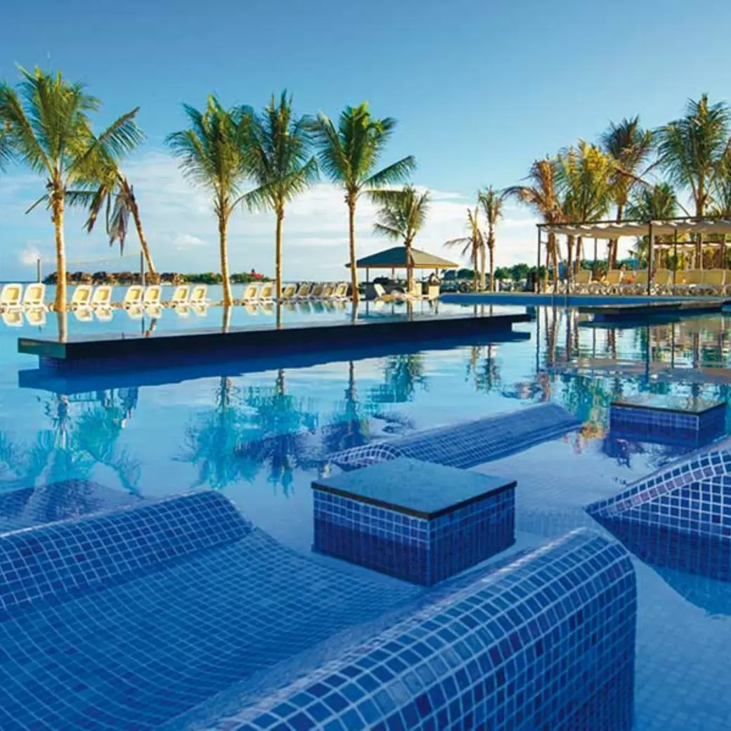 Hotel Riu Reggae infinity pool with submerged tile loungers and palm trees, Montego Bay