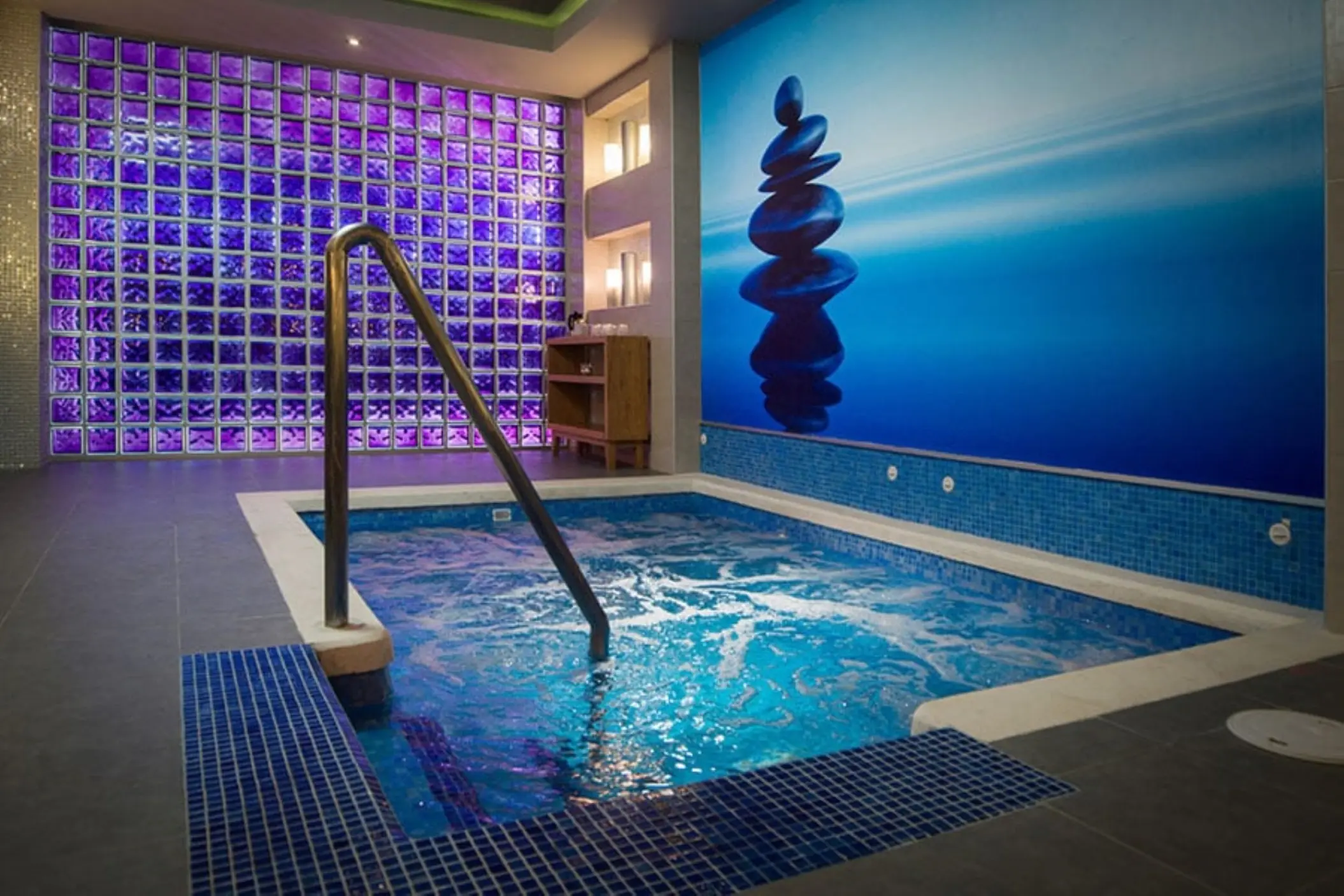 Indoor spa hydrotherapy pool with purple glass block wall at Riu Reggae, Montego Bay