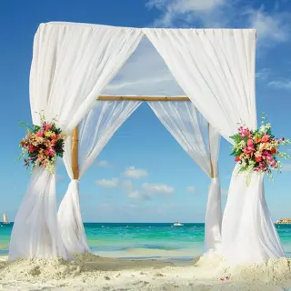 Beachfront wedding ceremony arch with white fabric at Riu Reggae, Montego Bay