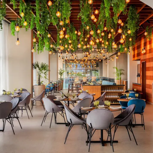 Aglio restaurant with hanging greenery and Edison bulbs at Hyatt Vivid Grand Island, Cancun