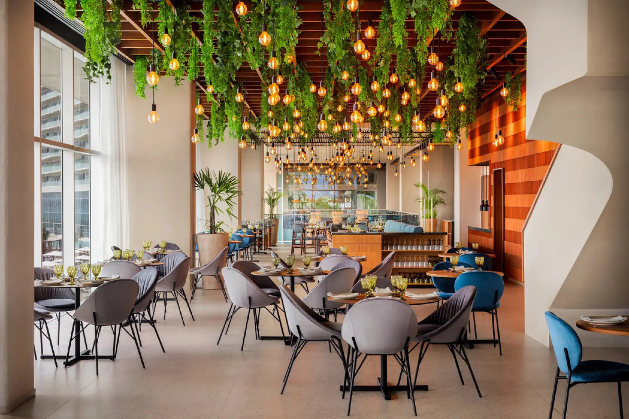 Aglio restaurant with hanging greenery and Edison bulbs at Hyatt Vivid Grand Island, Cancun