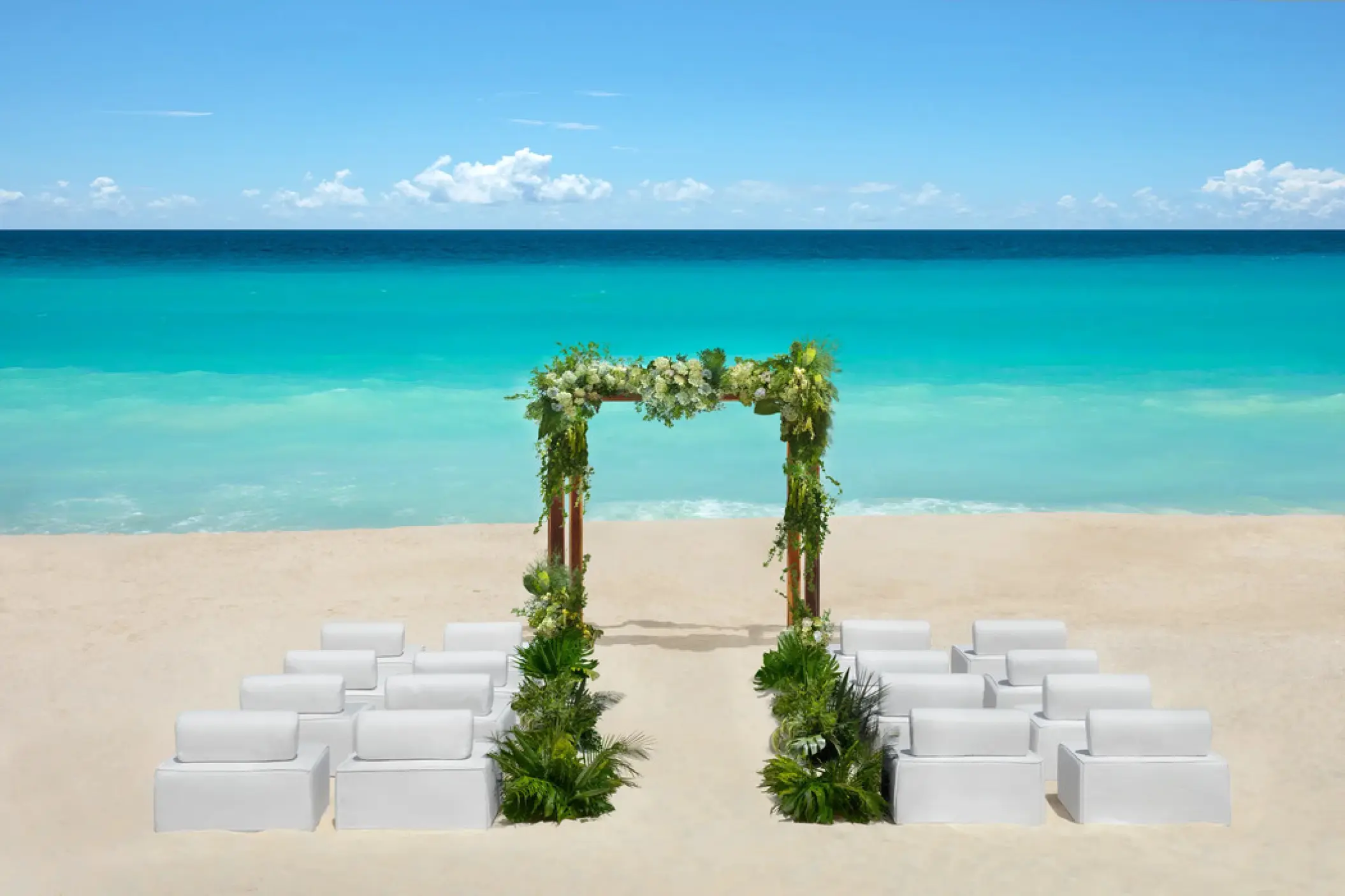 Beachfront wedding ceremony setup with floral arch at Hyatt Vivid Grand Island, Cancun