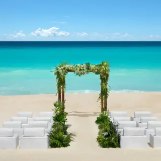 Beachfront wedding ceremony setup with floral arch at Hyatt Vivid Grand Island, Cancun