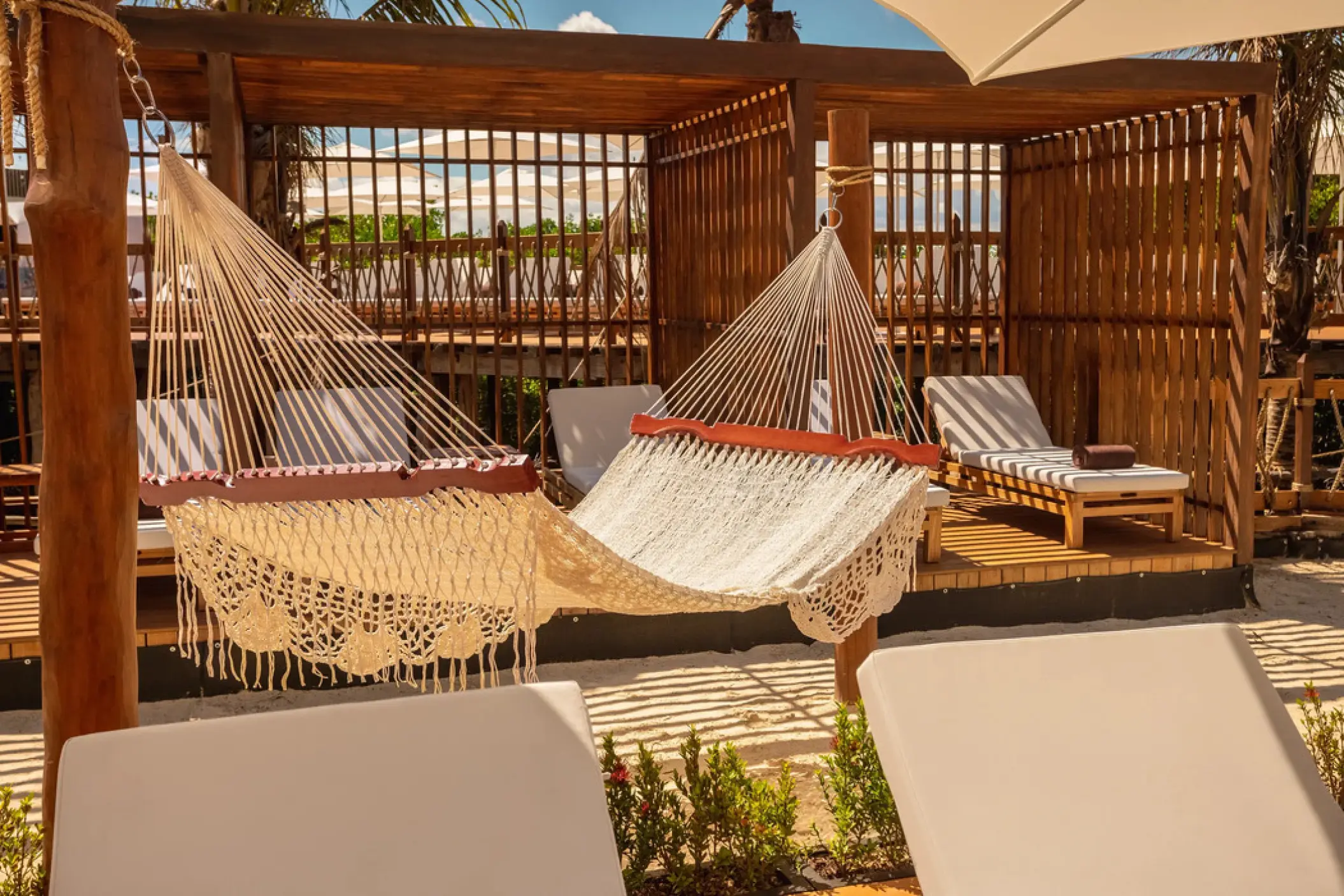 White macramé hammock and wooden beach cabanas at Hyatt Vivid Grand Island, Cancun