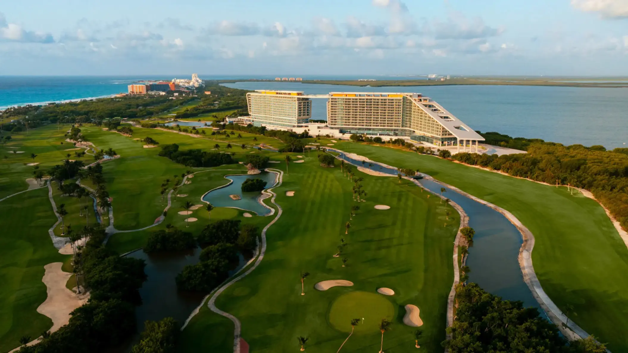 Aerial view of Hyatt Vivid Grand Island and golf course surrounded by water, Cancun