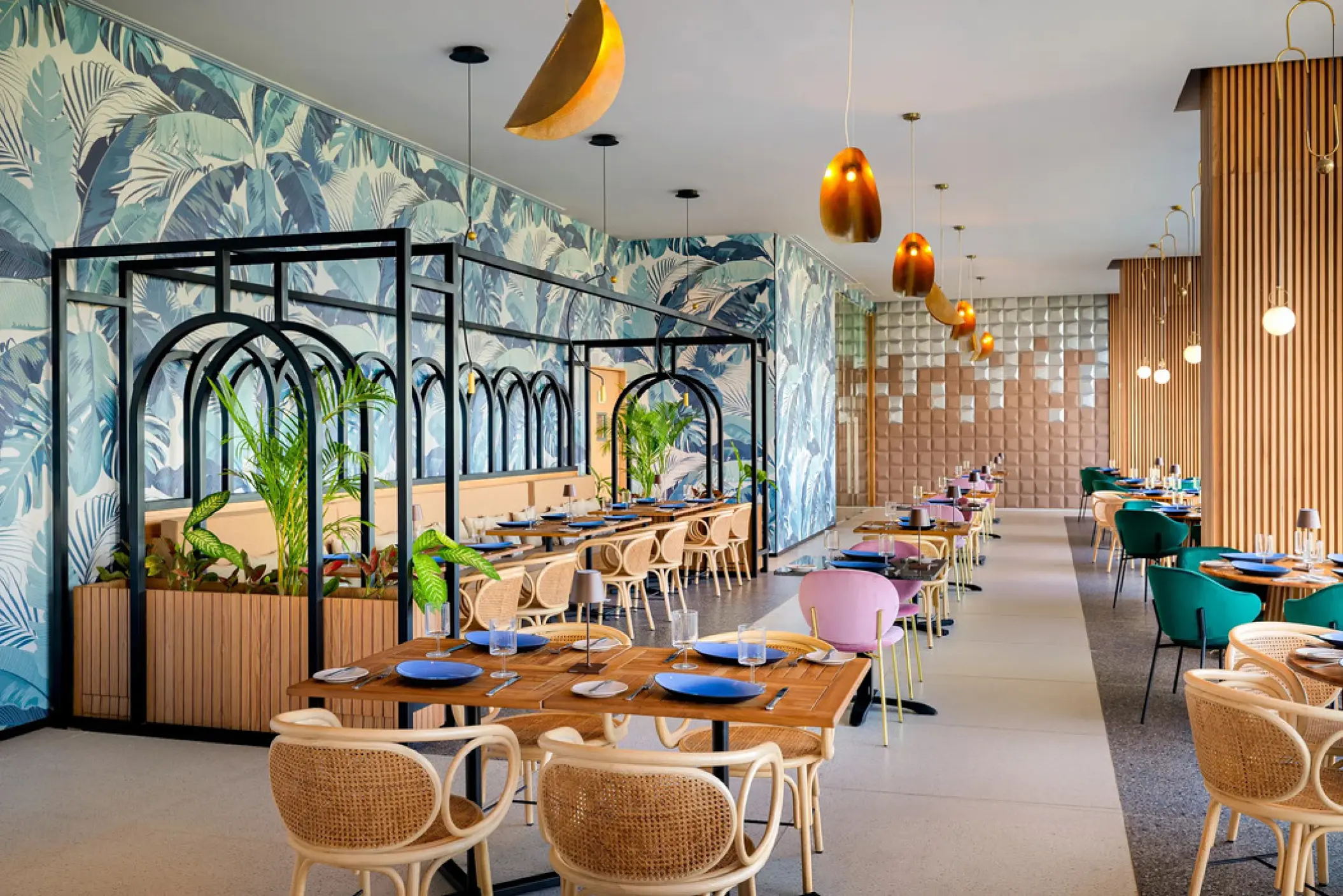 Le Lys restaurant with tropical leaf wallpaper and wicker chairs at Hyatt Vivid Grand Island, Cancun