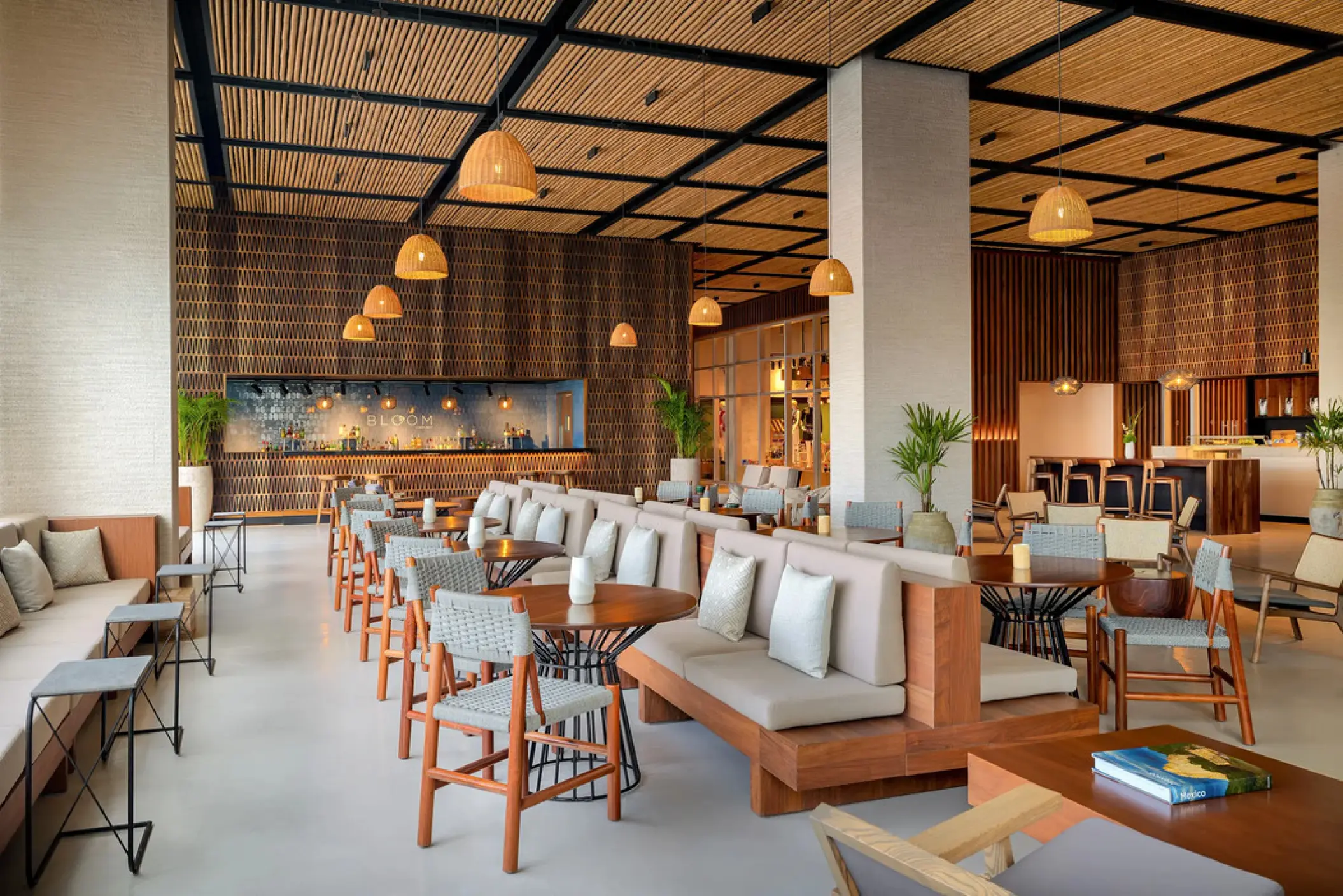 Modern lobby lounge with wooden ceiling slats and woven light fixtures at Hyatt Vivid Grand Island, Cancun