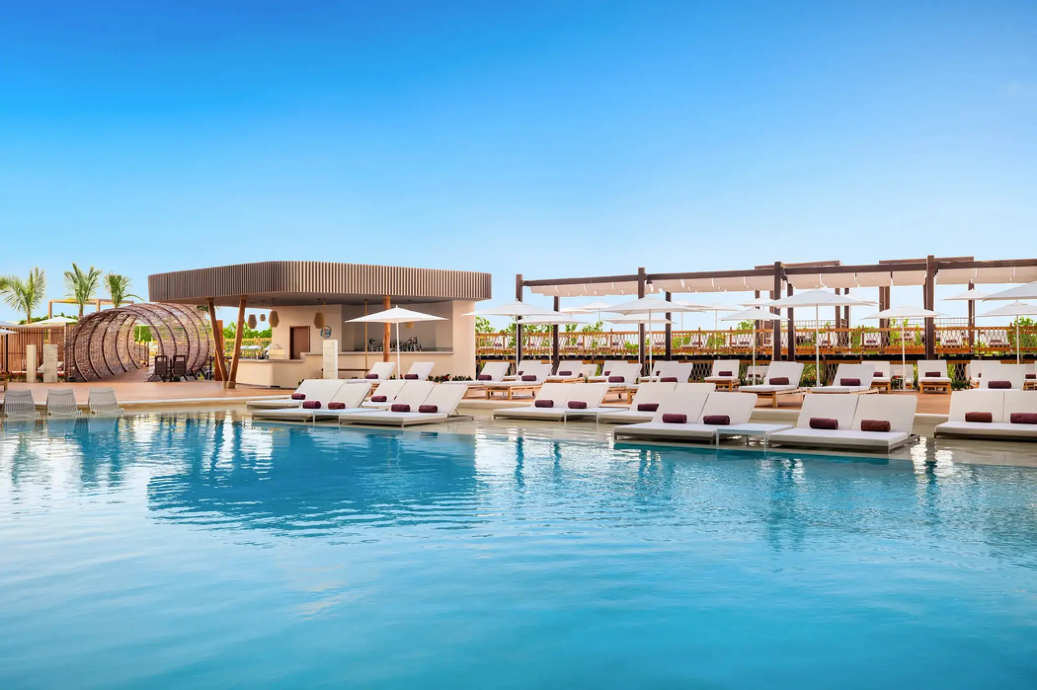 Main pool with swim-up bar and white lounge chairs at Hyatt Vivid Grand Island, Cancun