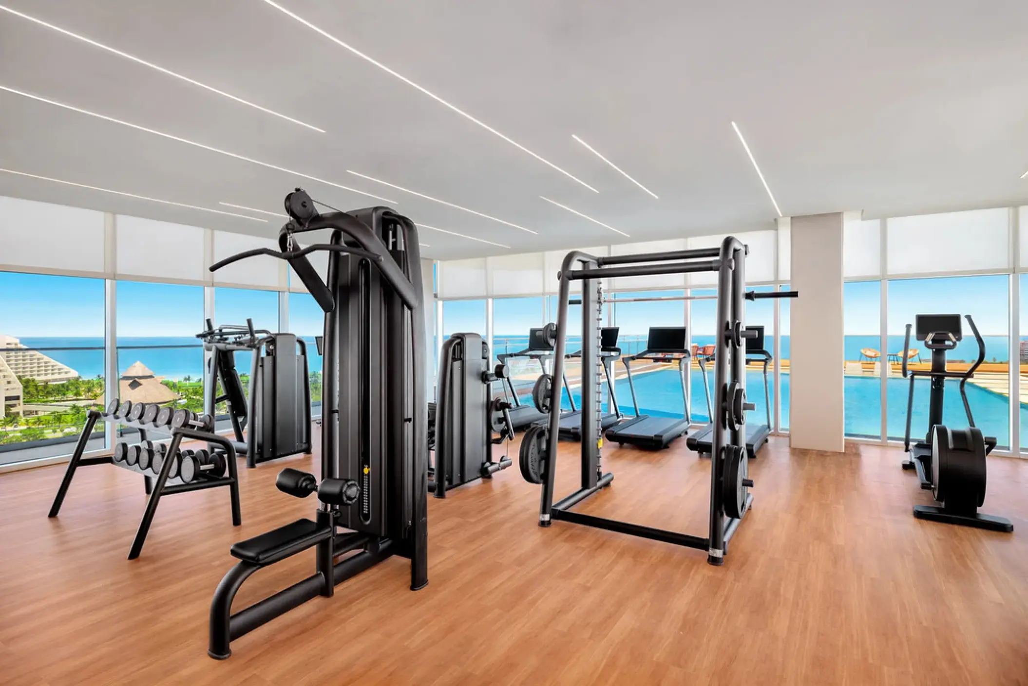 Rooftop gym with weight machines and treadmills overlooking the pool at Hyatt Vivid Grand Island, Cancun