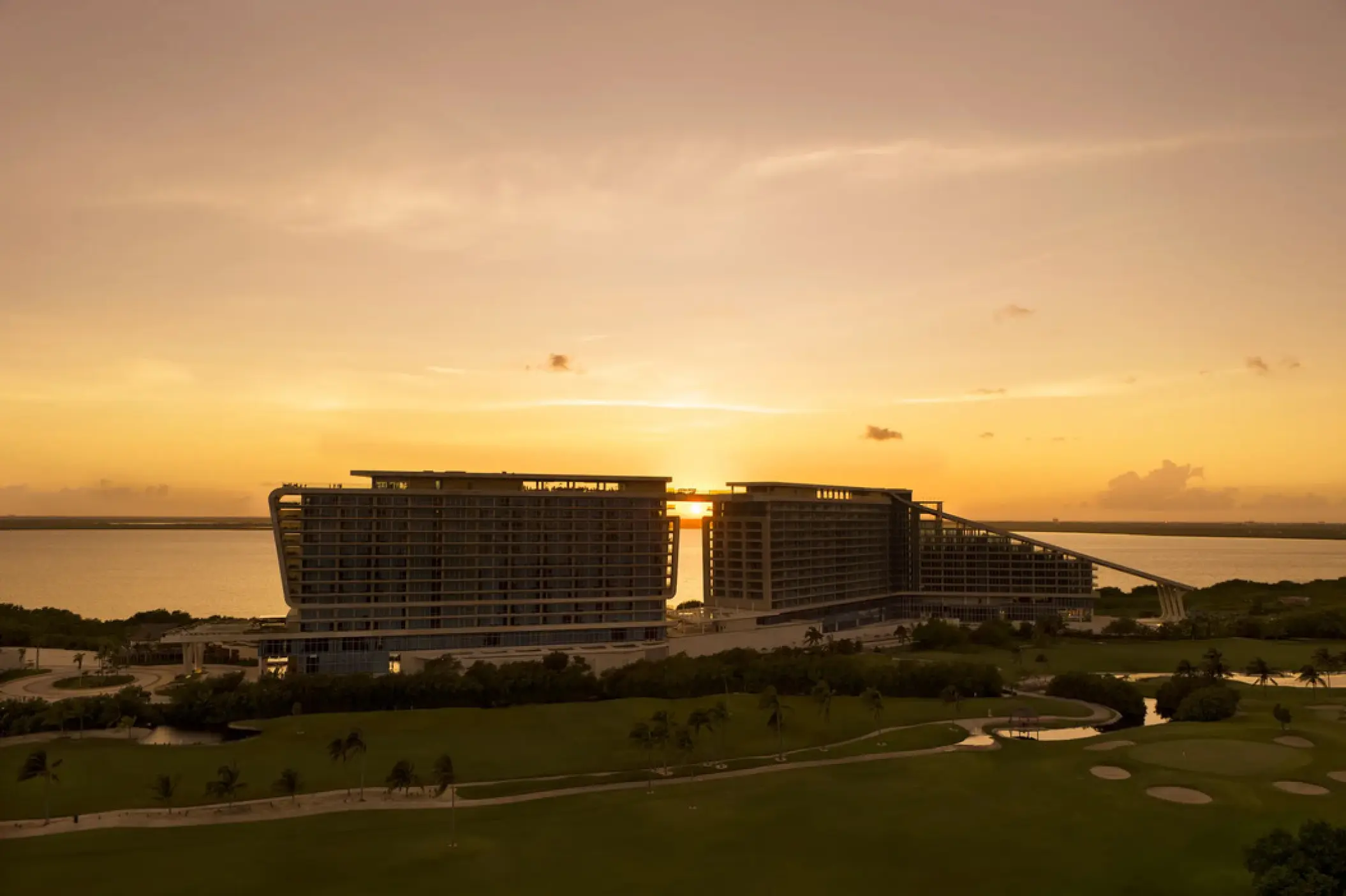 Sunset over the Hyatt Vivid Grand Island modern architecture and golf course, Cancun