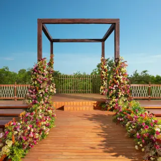 Wooden rooftop wedding ceremony gazebo with floral arrangements at Hyatt Vivid Grand Island, Cancun