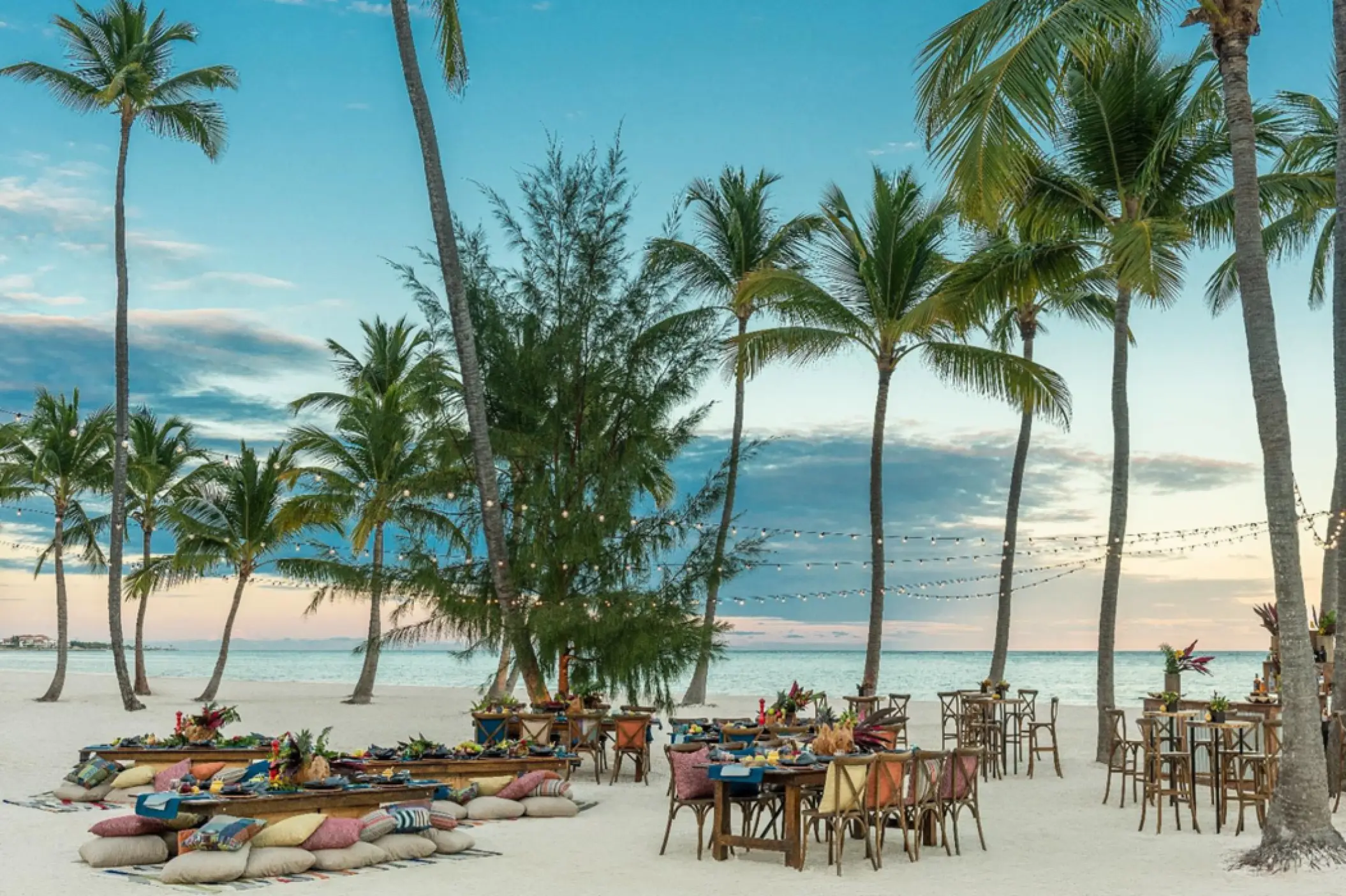 Beach wedding reception with floor cushions and string lights at Hyatt Zilara Cap Cana, Punta Cana