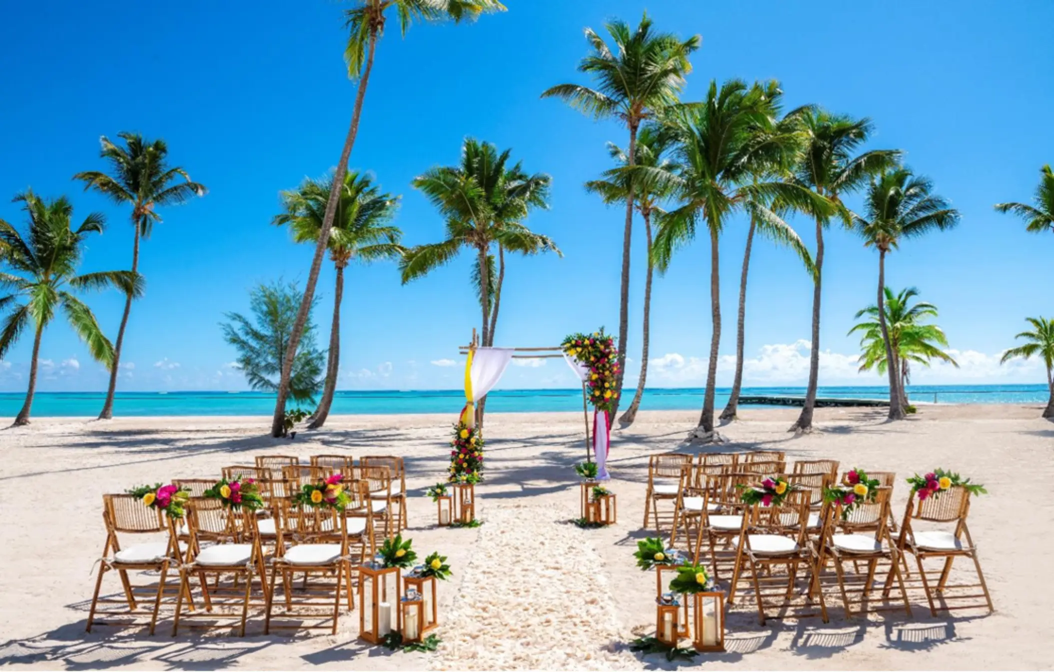 Beach wedding ceremony with bamboo chairs and palm trees at Hyatt Zilara Cap Cana, Punta Cana
