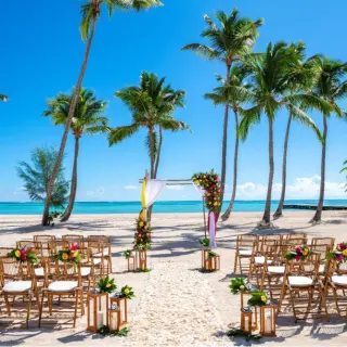 Beach wedding ceremony with bamboo chairs and palm trees at Hyatt Zilara Cap Cana, Punta Cana