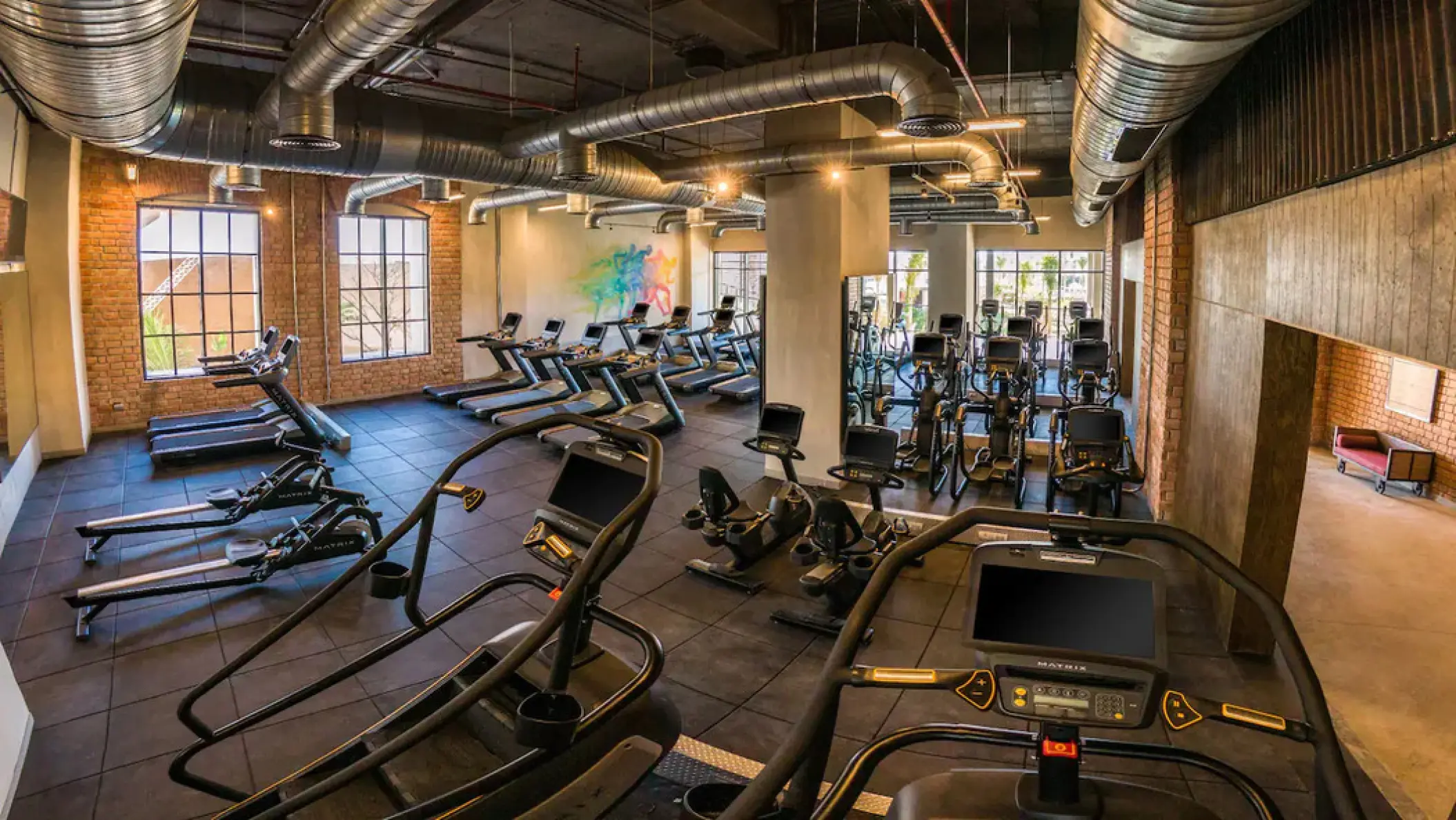 Industrial-style fitness center with treadmills and cardio equipment at Hyatt Zilara Cap Cana, Punta Cana