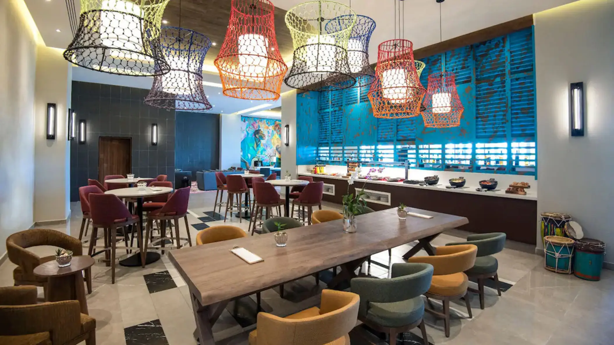 Colorful woven pendant lights over the Bongos restaurant seating at Hyatt Zilara Cap Cana, Punta Cana