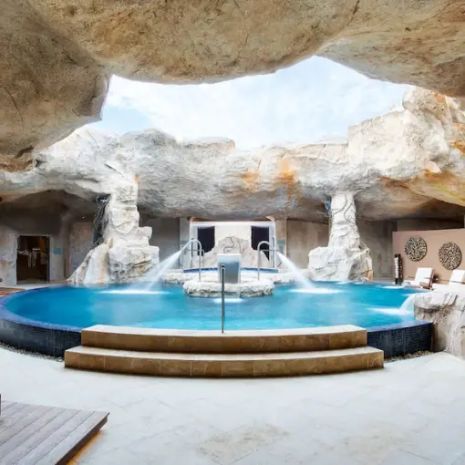 Cave-inspired indoor spa pool with water jets and lounge seating at Hyatt Zilara Cap Cana, Punta Cana