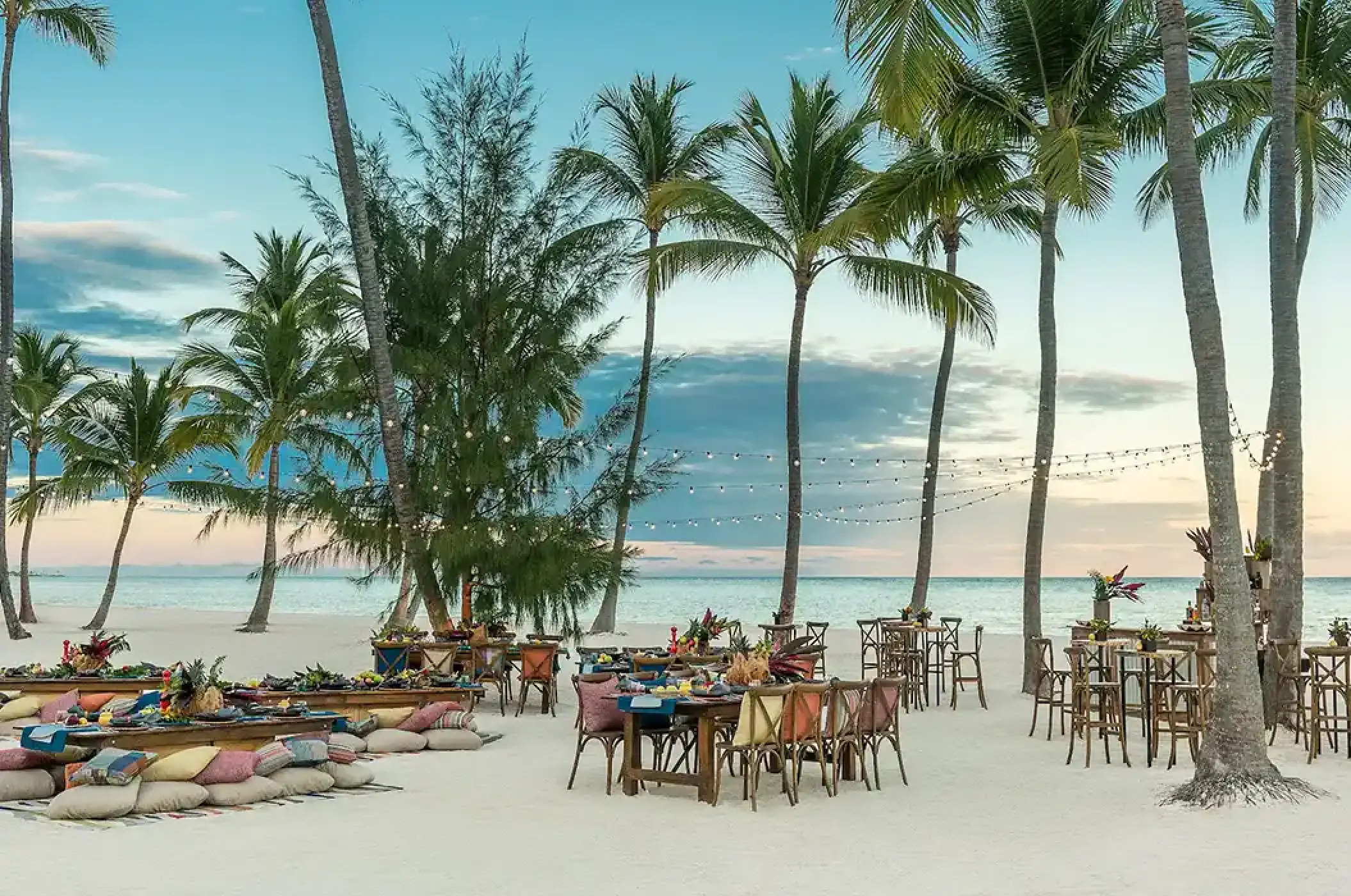Outdoor wedding reception setup with wooden tables and palm trees at Hyatt Zilara Riviera Maya, Riviera Maya