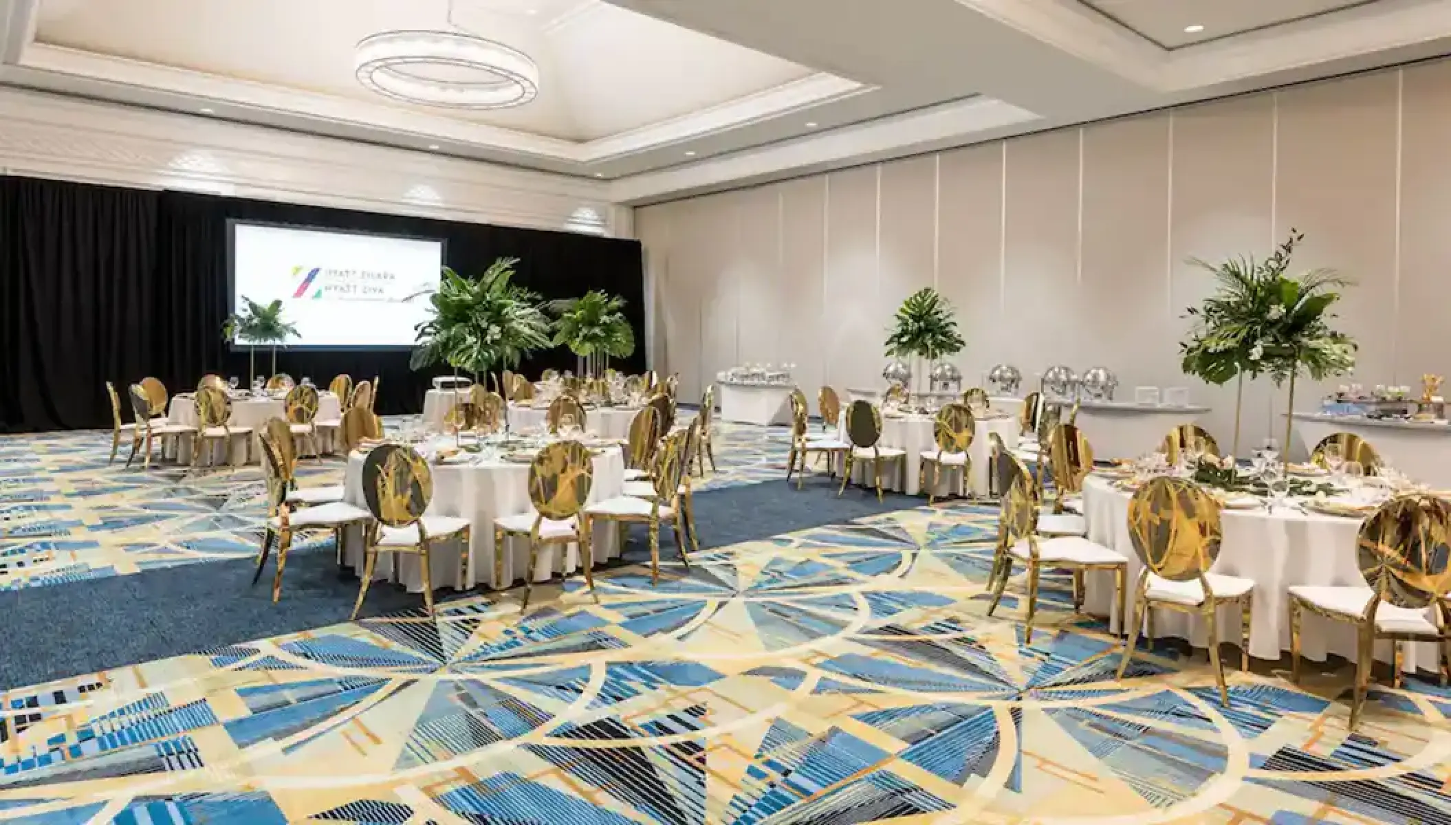 Indoor ballroom wedding reception with gold chairs and tropical centerpieces at Hyatt Zilara Rose Hall, Montego Bay