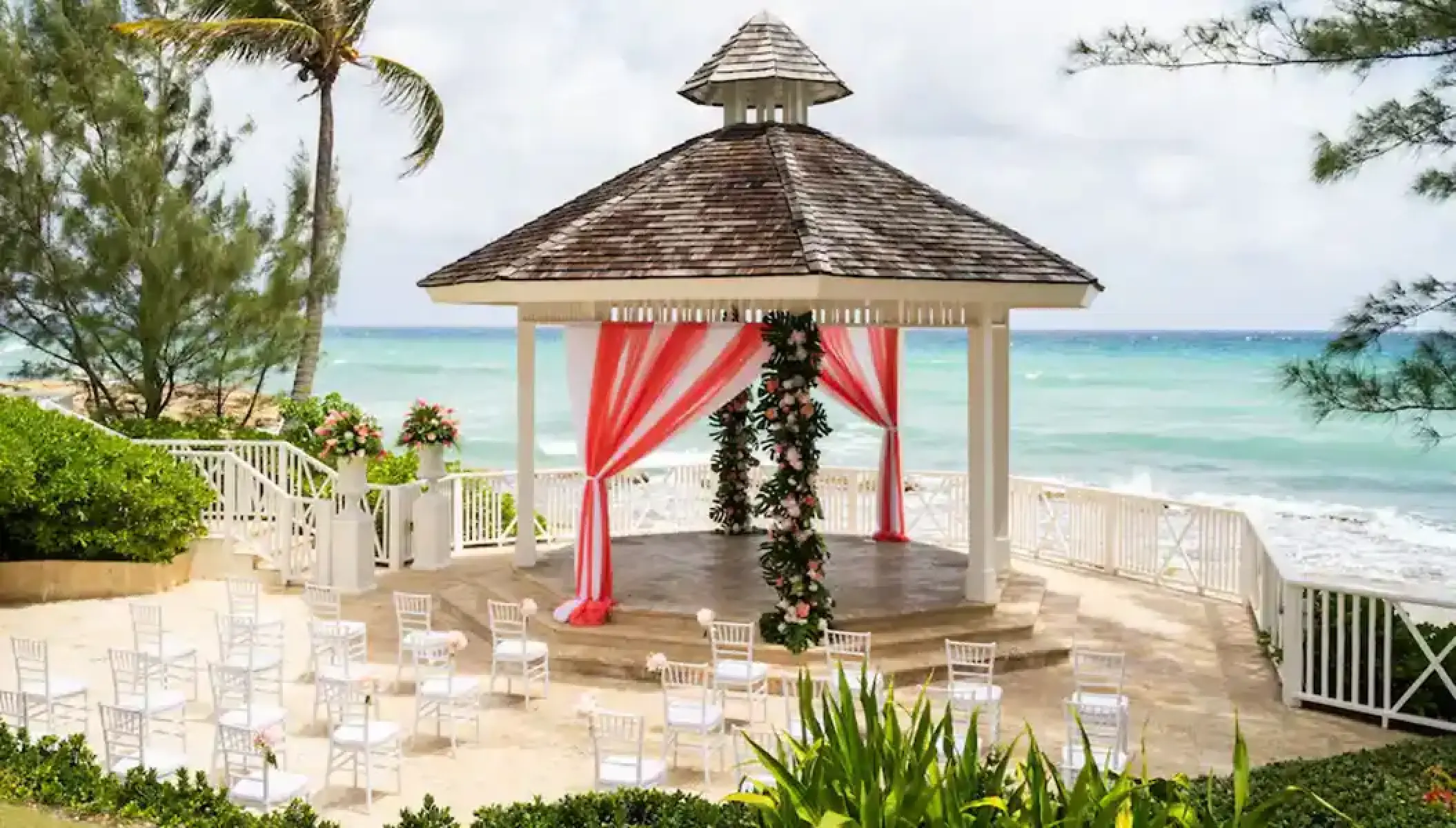Oceanfront wedding ceremony gazebo with red and white draping at Hyatt Zilara Rose Hall, Montego Bay