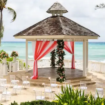 Oceanfront wedding ceremony gazebo with red and white draping at Hyatt Zilara Rose Hall, Montego Bay