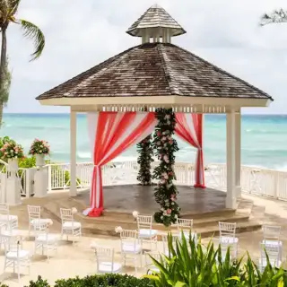 Oceanfront wedding ceremony gazebo with red and white draping at Hyatt Zilara Rose Hall, Montego Bay