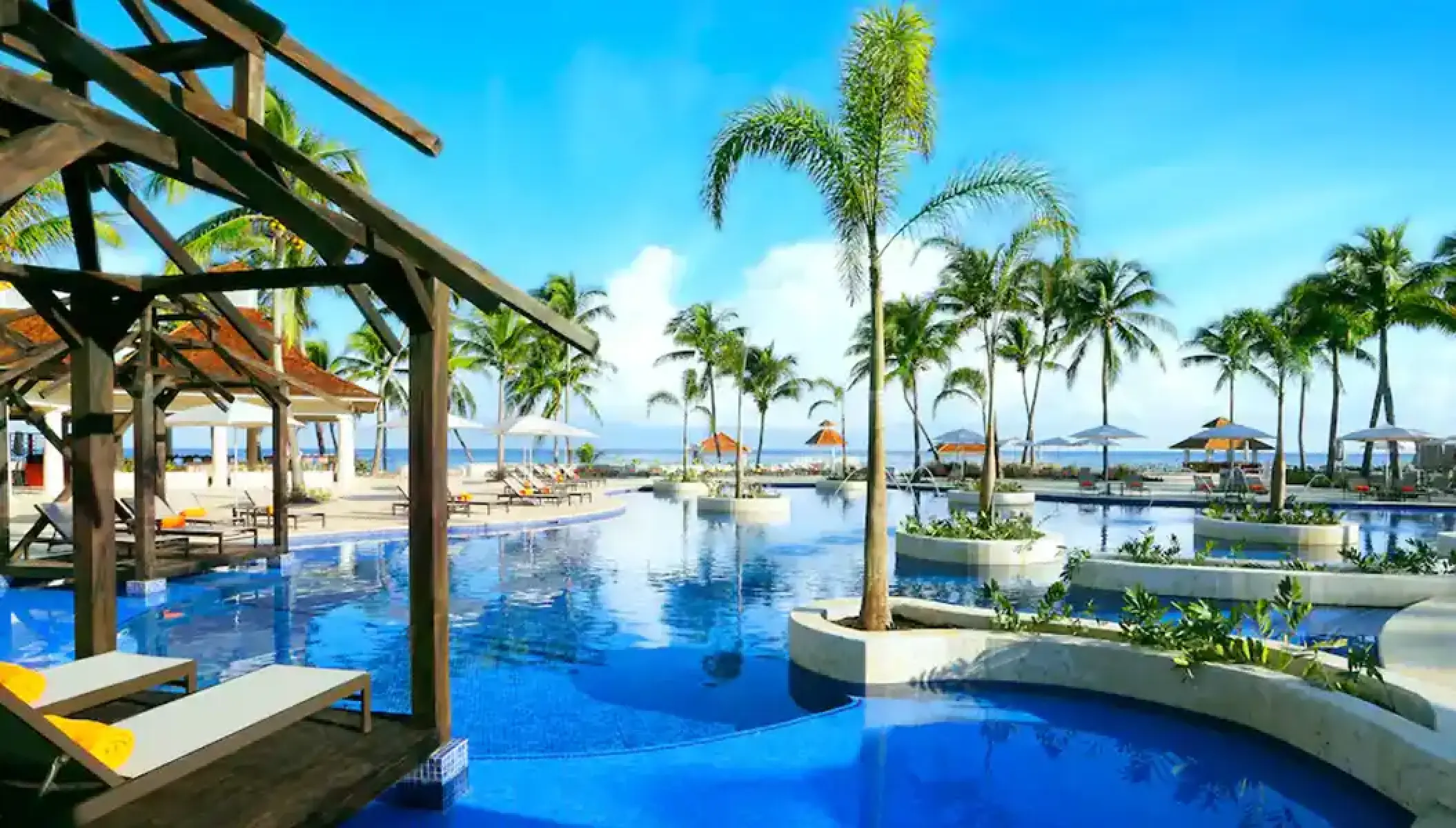 Main pool with palm tree islands and wooden cabanas at Hyatt Zilara Rose Hall, Montego Bay