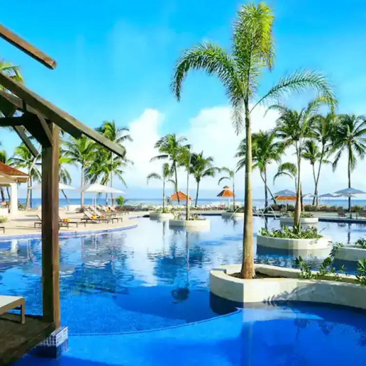 Main pool with palm tree islands and wooden cabanas at Hyatt Zilara Rose Hall, Montego Bay